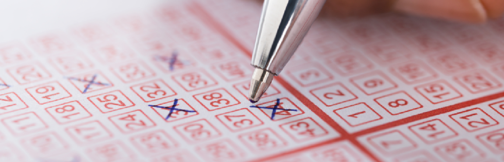 Image of a pen crossing numbers on a lottery ticket.